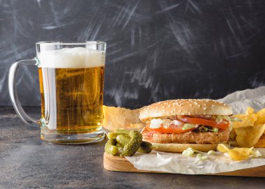 Tavuk burger ve bardak bira.