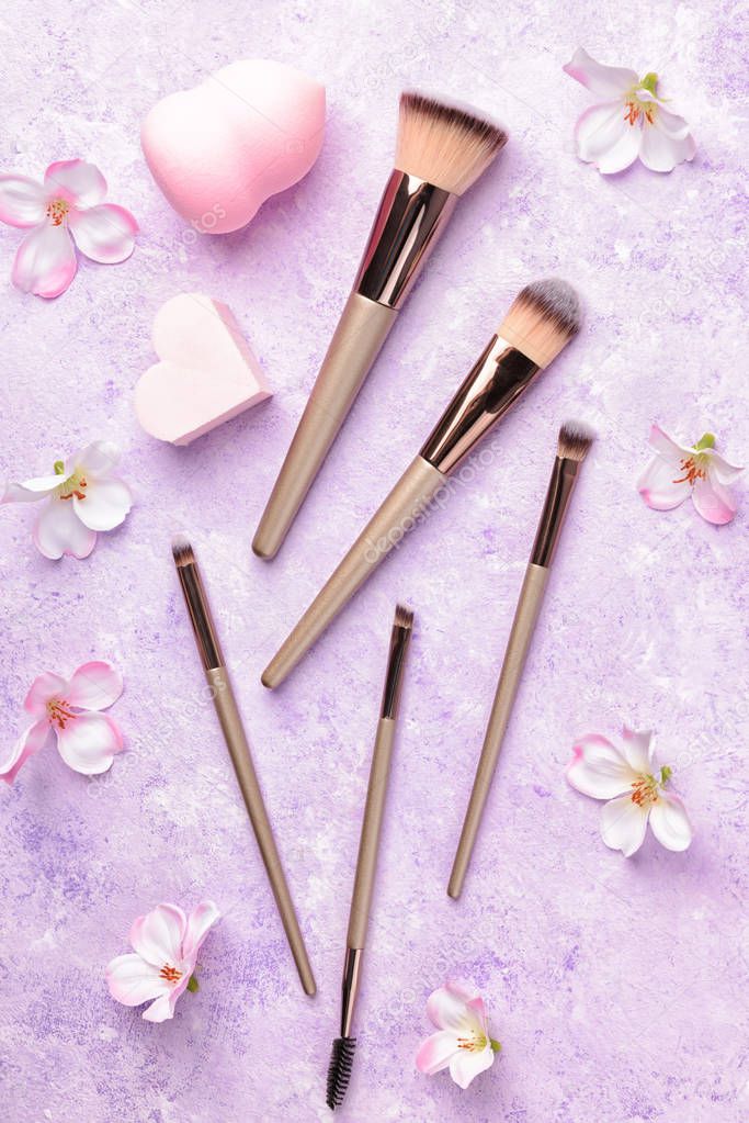 Set of makeup brushes on pink background.