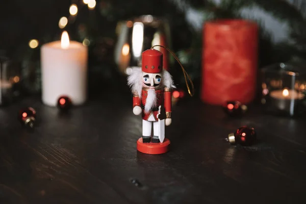 Christmas glowing small candle and fir tree branches on old wooden background — Stock Photo, Image