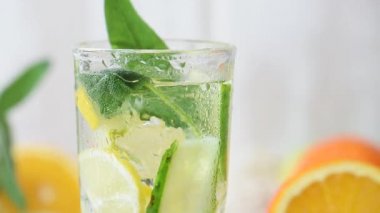 Damlalar ve buz küpleriyle dolu bir bardakta limonata. Meyve suyu, tahta bir masada yaz içeceği.