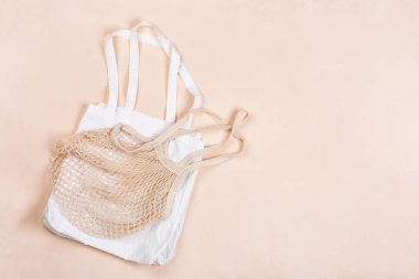 Bej renkli branda üzerinde tekrar kullanılabilir pamuk torbası. Çevre dostu kavram. Düz yat, boşluğu kopyala
