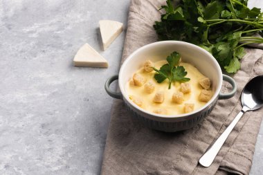 Peynirli krema çorbası, kızarmış ekmek ve mermer mermer masa üzerinde maydanoz. Düz konum, üst görünüm ve metin için boşluk kopyala