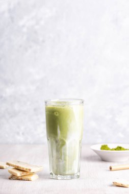 Hindistancevizi sütlü, ahşap ve mermer arka planda beyaz çikolatalı matcha latte.