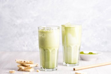 Hindistancevizi sütlü, ahşap ve mermer arka planda beyaz çikolatalı matcha latte.