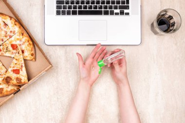 Karton kutuda pizza ve hafif mermer arka planda dizüstü bilgisayar. Metnin için alanı kopyala. Üst manzara, düz yatış. Paket yemek konsepti