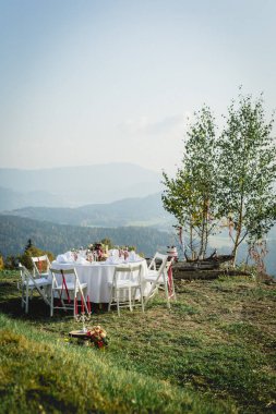 Gedeckter Hochzeitstisch vor wunderschner Berglandschaft in freier Natur