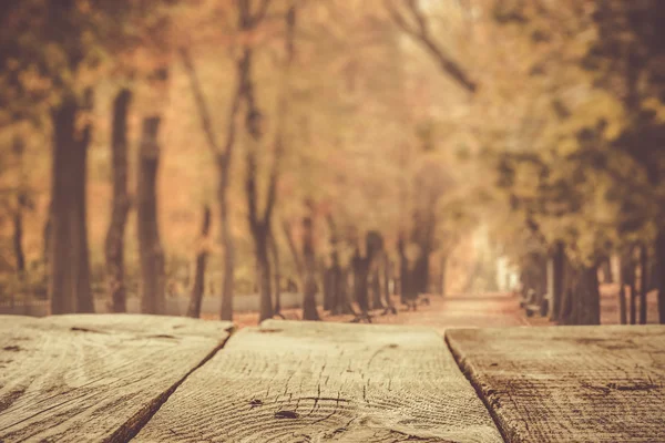Осенний фон с деревянным столом и парком — стоковое фото
