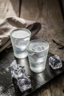 Kırsal ahşap arka planda shot bardaklarında votka