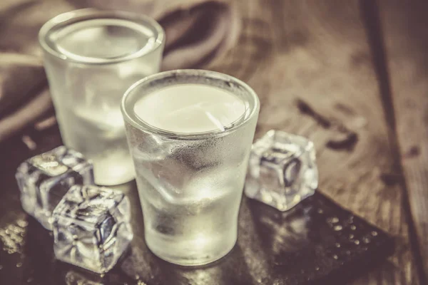 Wodka in shot glazen op rustieke houten achtergrond — Stockfoto