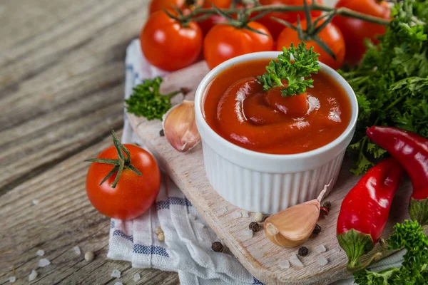 Ketchup and ingredients on wood background — Stock Photo, Image