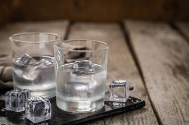 Kırsal ahşap arka planda shot bardaklarında votka