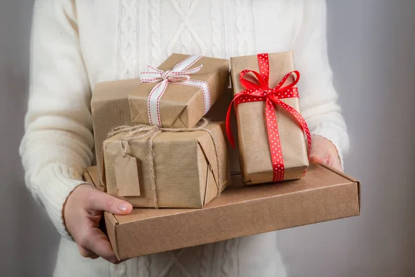 Frau hält Stapel von Weihnachtsgeschenken in der Hand — Stockfoto