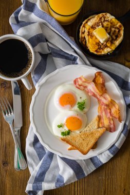 Amerikan kahvaltısı ile yumurta, pastırma, tost, krep, kahve ve meyve suyu kadar güneşli tarafı