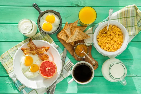 Summer breakfast - eggs, bacon, toast, jam, coffee, juice — Stock Photo, Image