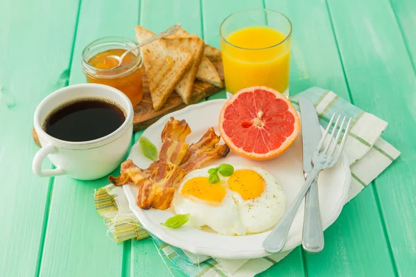 Desayuno de verano - huevos, tocino, tostadas, mermelada, café, jugo —  Fotos de Stock