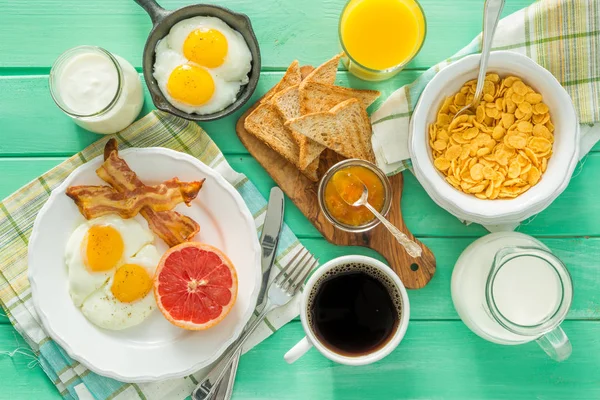 Desayuno de verano - huevos, tocino, tostadas, mermelada, café, jugo —  Fotos de Stock