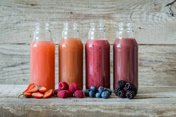 Selection of berry smoothies on rustic wood background — Stock Photo, Image
