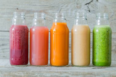 Rustik ahşap arka plan üzerinde renkli smoothies yelpazesi