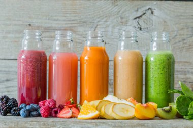 Rustik ahşap arka plan üzerinde renkli smoothies yelpazesi
