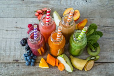 Rustik ahşap arka plan üzerinde renkli smoothies yelpazesi