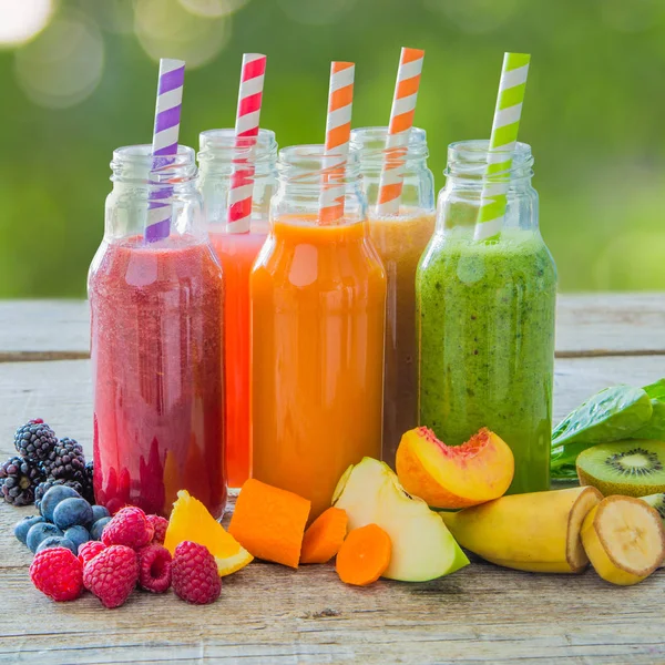Rustik ahşap arka plan üzerinde renkli smoothies yelpazesi