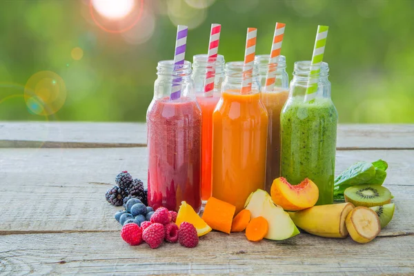 Rustik ahşap arka plan üzerinde renkli smoothies yelpazesi