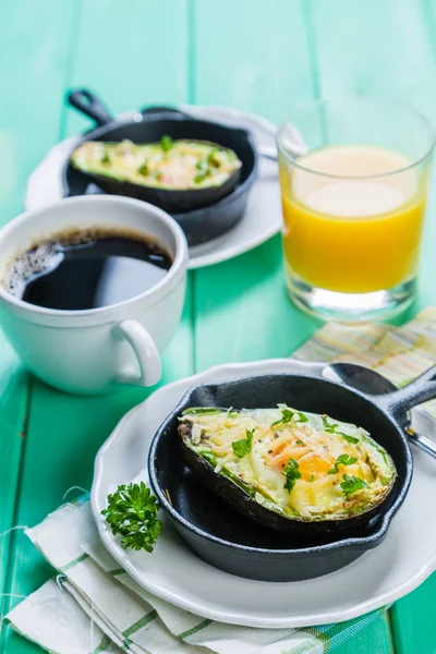 Frukost - bakad avokado med ägg, kaffe och juice — Stockfoto