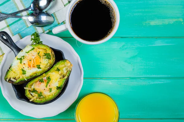 Завтрак - запеченный авокадо с яйцами, кофе и соком — стоковое фото