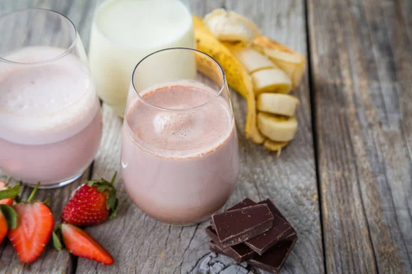 Ízesített tej - eper, csokoládé, banán választéka — Stock Fotó