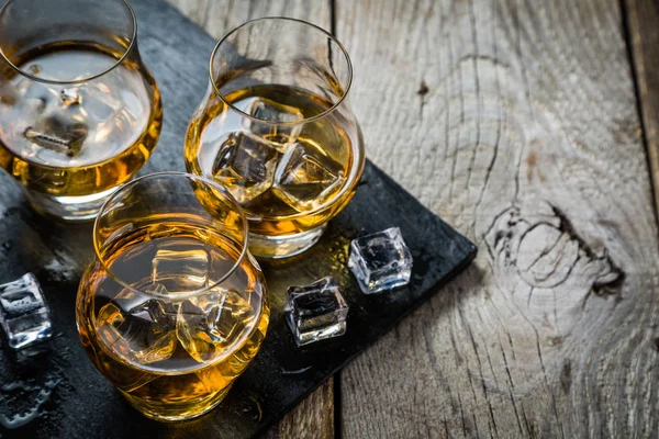 Whiskey with ice in glasses — Stock Photo, Image
