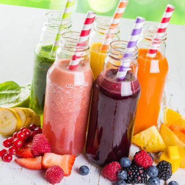 Rustik ahşap arka plan üzerinde renkli smoothies yelpazesi