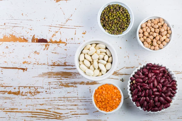 Selection of colorful beans on white wood background — Stock Photo, Image