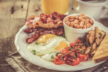 Tam İngiliz kahvaltısı - yumurta, pastırma, fasulye, kızarmış ekmek, kahve ve meyve suyu