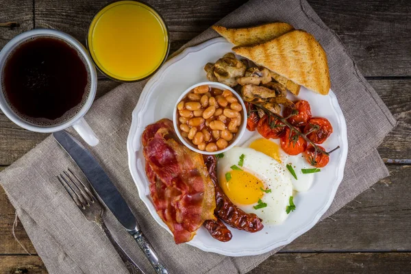 Полный английский завтрак - яйца, бекон, бобы, тосты, кофе и сок — стоковое фото