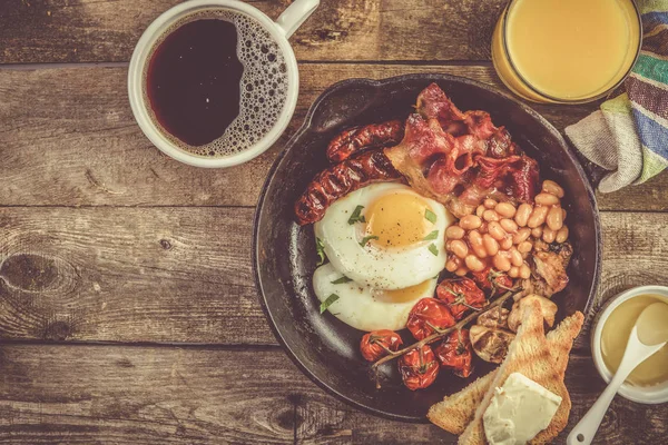 Полный английский завтрак - яйца, бекон, бобы, тосты, кофе и сок — стоковое фото