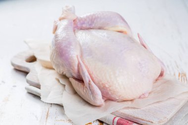 Otlar ve baharatlar rustik ahşap arka plan üzerinde ham bütün tavuk