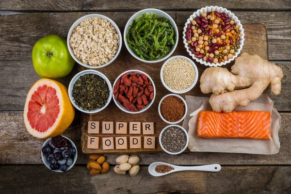 Auswahl an Superfoods auf rustikalem Hintergrund — Stockfoto