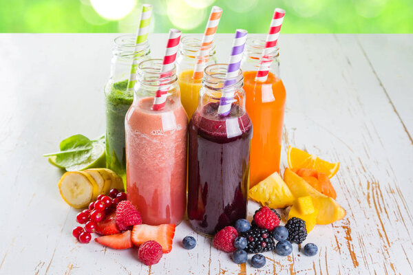 Selection of colourful smoothies on rustic wood background
