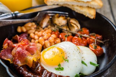 Tam İngiliz kahvaltısı - yumurta, pastırma, fasulye, kızarmış ekmek, kahve ve meyve suyu