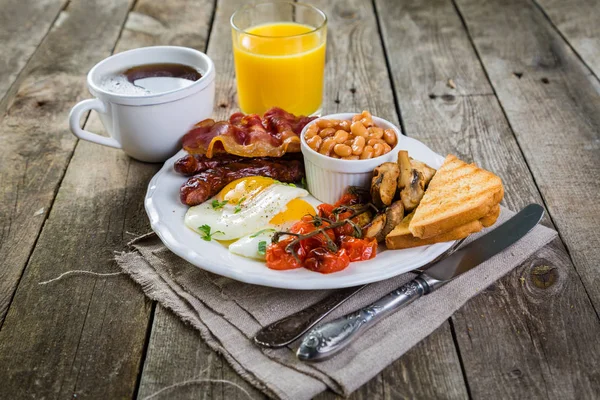 Full english breakfast - eggs, bacon, beans, toast, coffee and juice — Stock Photo, Image