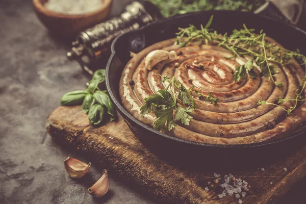 Salsichas de churrasco na panela de ferro fundido — Fotografia de Stock