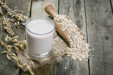 Oat milk alternative on rustic wood background clipart
