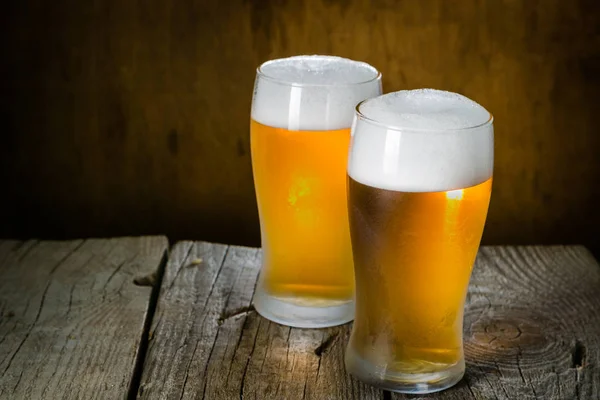 Birra in tazze ghiacciate su sfondo rustico — Foto Stock