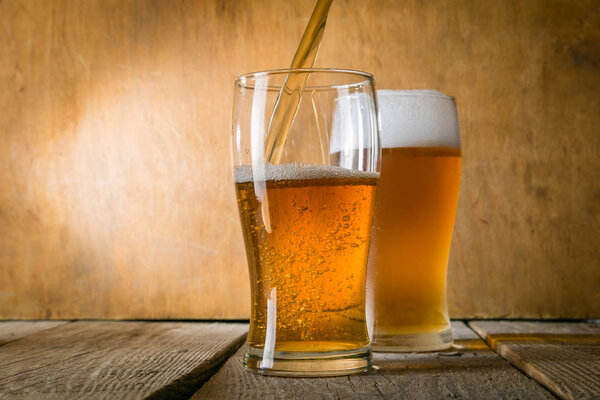 Beer in frosty mugs on rustic background