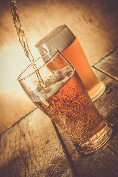 Beer in frosty mugs on rustic background