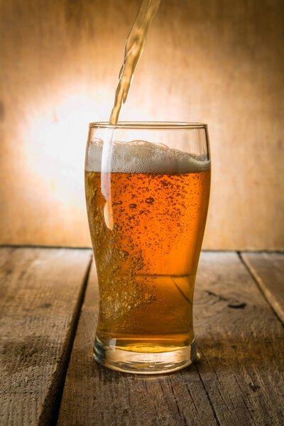 Beer in frosty mugs on rustic background