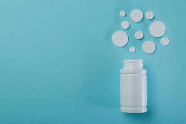 Concept médical - différentes formes de pilules blanches sur fond bleu — Photo