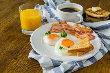 Amerikan kahvaltısı ile yumurta, pastırma, tost, krep, kahve ve meyve suyu kadar güneşli tarafı