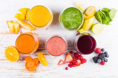 Rustik ahşap arka plan üzerinde renkli smoothies yelpazesi