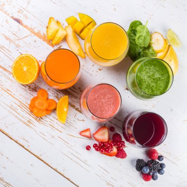 Rustik ahşap arka plan üzerinde renkli smoothies yelpazesi